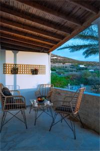 2 sillas y una mesa en un patio con vistas en Noho Villas @ Sunlit house Paros, en Nea Cryssi Akti