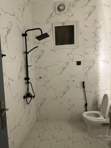 a white bathroom with a toilet and a shower at Riyadh Cozy Stylish One-Bedroom Apartment in Riyadh