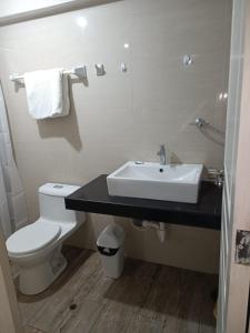 y baño con lavabo y aseo. en Departamentos Cristo Rey 3 en Tacna