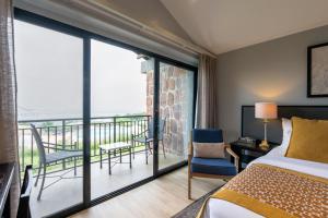 ein Hotelzimmer mit einem Bett und einem Balkon in der Unterkunft Mantis Akagera Game Lodge in Akagera