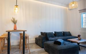 a living room with a blue couch and a table at Noho Villas @ Sunlit house Paros in Nea Cryssi Akti
