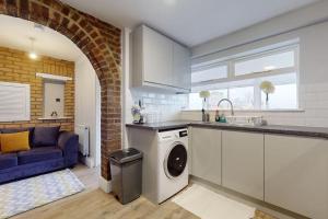 a kitchen with a washing machine in the middle of a kitchen at CONeN Dagenham Home in Goodmayes