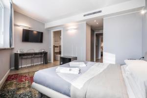 1 dormitorio con 1 cama blanca y TV en Golgi Suite, en Pavia