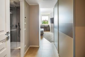 a bathroom with a walk in shower and a glass door at Golgi Suite in Pavia