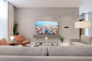 a living room with a couch and a painting on the wall at أكاريم الملقا Akareem AL-Malqa in Riyadh +130 photos