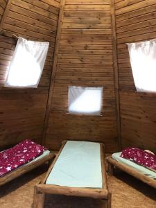 a room with three beds in a wooden wall at Nádas fogadó és panzió in Teresztenye