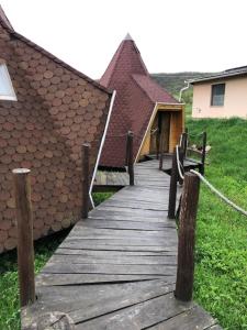 een houten loopbrug naast een gebouw met een huis bij Nádas fogadó és panzió in Teresztenye