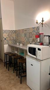 a kitchen with a counter with a microwave and stools at Bed and breakfast chez l'habitant in Marseille