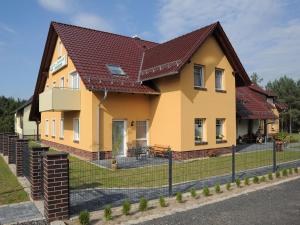 una casa amarilla con techo rojo en 2-room apartment in Lübben in the Spreewald en Lübben