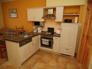 a kitchen with white cabinets and a sink and a stove at 2-room apartment in Lübben in the Spreewald in Lübben