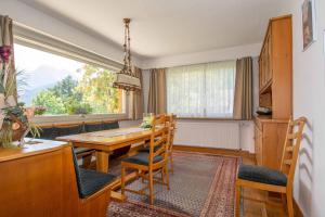 een eetkamer met een tafel en stoelen en een raam bij Chalet Grimm in Adelboden