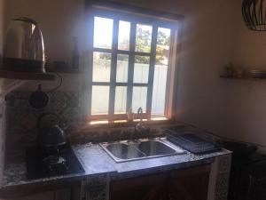 a kitchen with a sink and a window at Casa Jasmim in Imbituba