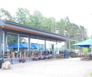 a building with blue umbrellas and tables and chairs at Sea View Design Studio near metro in Espoo in Espoo