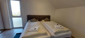 um pequeno quarto com 2 camas e toalhas em Hotel Kalenborner Höhe em Kalenborn