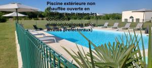 una piscina con sedie e ombrelloni accanto a una recinzione di Villa Bellagio Amboise by Popinns a Amboise