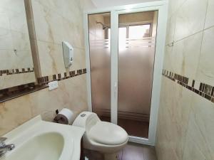 a bathroom with a toilet and a sink and a shower at Bienvenido a tu casa en Baños in Baños