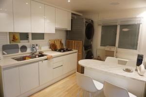 een keuken met witte kasten en een aanrechtblad bij NEW OPEN-Oublier,SEOUL STN 5min by walk,Cozy Home in Seoul +32 foto's