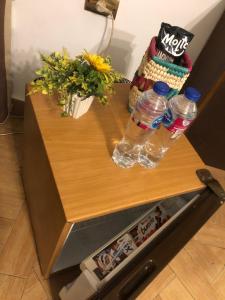 einen Tisch mit zwei Flaschen Wasser und Blumen darauf in der Unterkunft cozy room near the airport in Kairo