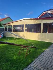 una mesa de picnic en el césped frente a un edificio en Restaurace a penzion u Jessyho, en Perná