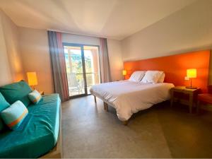 a bedroom with a large bed and a couch at DANS LES BRAS DE NEPTUNE - Plage de TRESTRAOU - Piscine - 4 à 5 personnes in Perros-Guirec +15 photos