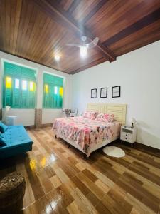 a bedroom with a bed and a wooden floor at Casa com Piscina in Canavieiras