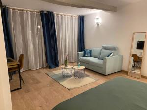 ein Wohnzimmer mit einem Sofa und einem Tisch in der Unterkunft Nuits centre : superbe gîte rénové et climatisé in Nuits-Saint-Georges