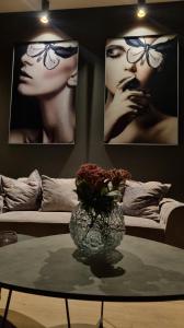 un soggiorno con tavolo e vaso con fiori di TRESOR Delux Apartment a Osijek