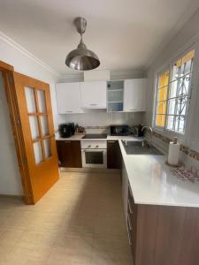 a kitchen with white cabinets and a sink at Villa Lilibella in San Juan de los Terreros
