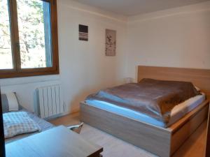 1 dormitorio con cama y ventana en Très agréable 2 pièces au pied des pistes, en Valdeblore