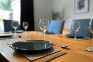 a table with a plate and wine glasses on it at Collingwood House by StayStaycations in Bristol