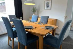 a wooden table with chairs and wine glasses on it at Collingwood House by StayStaycations in Bristol