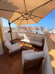 a balcony with a couch and an umbrella at Villa Lilibella in San Juan de los Terreros
