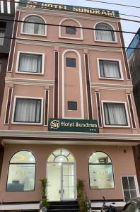 un edificio rosa con un cartello dell'hotel di Hotel Sundram a Zirakpur