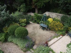 an overhead view of a garden with a bench and an umbrella at Barn End in Chippenham