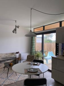 een woonkamer met een witte tafel en stoelen bij Calico, dépendance proche Hossegor et 15 min plage in Saubion
