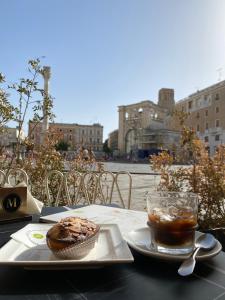 a table with a plate of food and a cup of coffee at Oronti Accommodations in Lecce