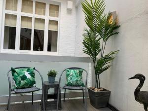 une terrasse avec deux chaises et une plante en pot dans l'établissement Hyde Park 3bed with patio as seen on TV House Hunters International, à Londres