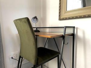 uma secretária com uma cadeira e uma mesa com um espelho em Cosy Comfort Guest Suit em Durban