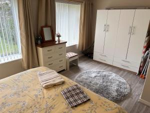 - une chambre avec un lit et une commode dans l'établissement Feorline Cottage, à Lochgoilhead