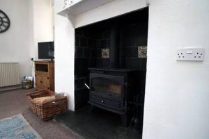 a living room with a black stove in a room at The Cornish Nook by StayStaycations in Camelford