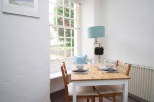 a dining room table with two chairs and a lamp at The Cornish Nook by StayStaycations in Camelford