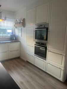 a kitchen with white cabinets and an oven at Huseby - Perfect for World Cup Trondheim 2025 in Trondheim