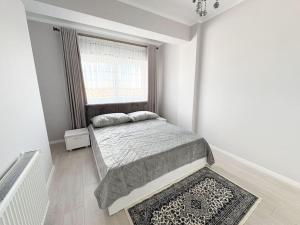 um quarto branco com uma cama e uma janela em Radauti Residence 12G em Rădăuţi