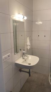 ein weißes Badezimmer mit einem Waschbecken und einem Spiegel in der Unterkunft NOVÝ krásný apartmán - 15 min od centra in Prag