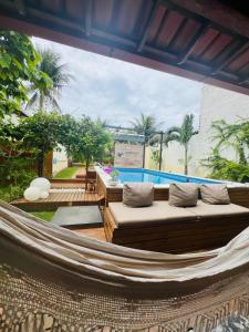 a hammock on a patio with a pool at Casa com Piscina in Canavieiras