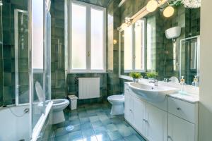 ein Badezimmer mit zwei Waschbecken, einem WC und einer Dusche in der Unterkunft Vatican Apartment Borgo Pio in Rom