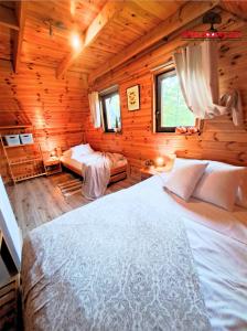 a bedroom with a bed in a wooden cabin at Wierzbowy Jar- kameralny domek przy lesie w Rudawach Janowickich stworzony dla osób szukających spokoju in Janowice Wielkie