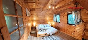 a bedroom with a bed in a wooden room at Wierzbowy Jar- kameralny domek przy lesie w Rudawach Janowickich stworzony dla osób szukających spokoju in Janowice Wielkie