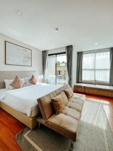 The Proud Rawai Resort في شاطئ راوايْ: غرفة نوم كبيرة مع سرير كبير وأريكة +35 صورة