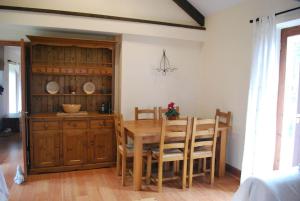 a dining room with a table and wooden cabinets at Barn conversion near the coast in Paignton